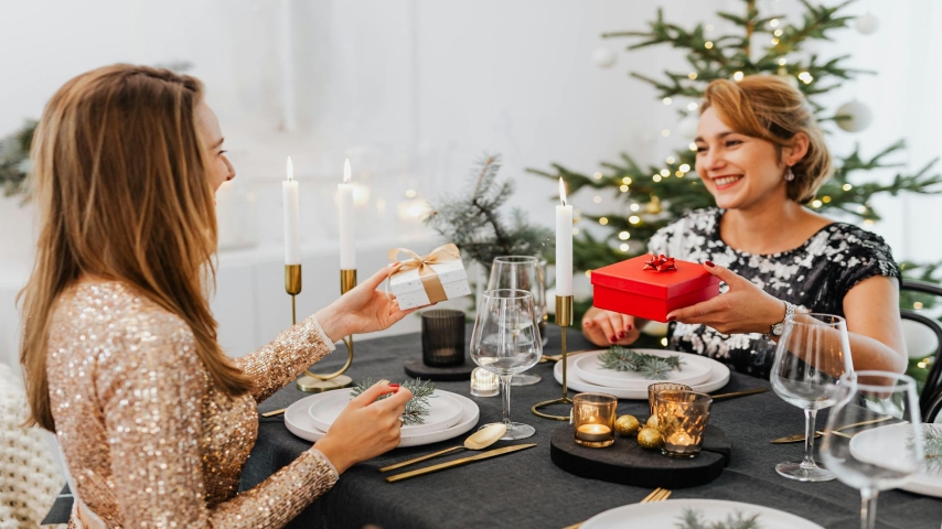 Friends Exchanging Christmas Gifts at Dinner: https://www.pexels.com/photo/friends-exchanging-christmas-gifts-at-dinner-5469708/